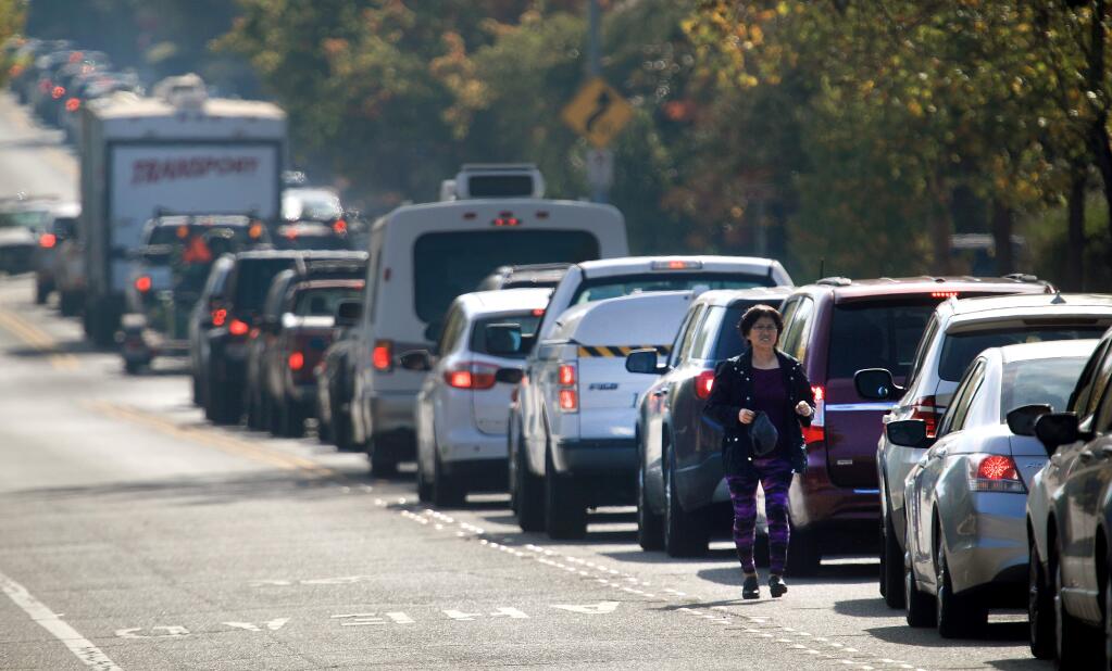A woman transfers to another car on Hembree Lane in Windsor as residents evacuate from the threat of the Kincade fire on Saturday, Oct. 26, 2019. (Kent Porter / The Press Democrat)