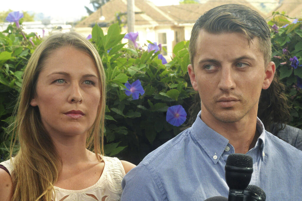 FILE - Denise Huskins, left, and her boyfriend, Aaron Quinn listen as their attorneys speak at a news conference on July 13, 2015, in Vallejo, Calif. Huskins, who was kidnapped from her boyfriend’s Northern California home and released two days later and whose case was first dismissed as a hoax by law enforcement, is generating renewed attention as the subject of a new Netflix documentary. (Mike Jory/The Times-Herald via AP, File)