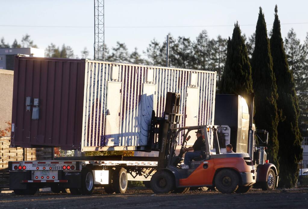 BETH SCHLANKER / The Press Democrat Glen Ghilotti of Team Ghilotti uses a forklift to unload a shipping container doubling as a temporary housing unit for an area called Oasis Village in Santa Rosa on Wednesday.