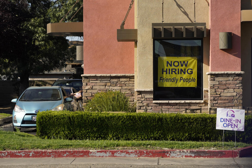A hiring sign hangs in the window of a Taco Bell in Sacramento, Calif., Thursday, July 15, 2021. Hiring in California slowed down in June as the unemployment rate held steady at 7.7% according to new numbers released on Friday, July 16, 2021 by the Employment Development Department. California gained 73,000 jobs in June, ending the state's streak of four consecutive months of adding 100,000 jobs or more. But experts say the state is still struggling from a workforce shortage as California has added back just over half of the 2.7 million jobs it lost at the start of the pandemic.(AP Photo/Rich Pedroncelli))