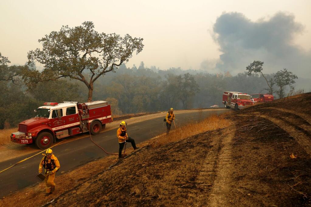 Sonoma County Fire District firefighters mop up a large spot fire from the Kincade Fire, off Los Amigos Road in Windsor, California, on Sunday, October 27, 2019. (Alvin Jornada / The Press Democrat)