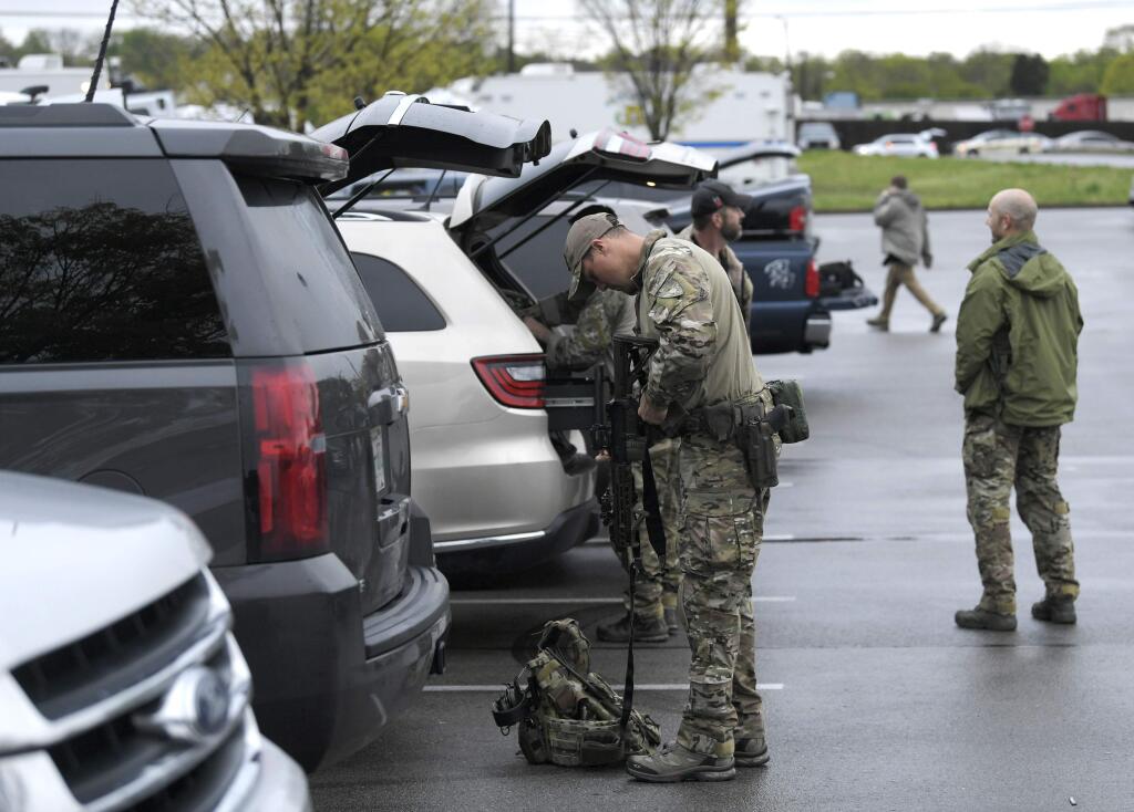 Law enforcement personnel gather Monday, April 23, 2018, at the police command post across from the Waffle House where several people were shot and killed by a gunman early Sunday morning in Nashville, Tenn. The suspect is still at large. (Shelley Mays/The Tennessean via AP)