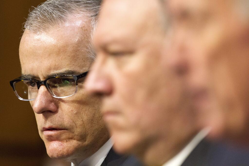 Acting FBI Director Andrew McCabe, left, and CIA Director Mike Pompeo, center, listen as Director of National Intelligence Dan Coats testifies on Capitol Hill in Washington, Thursday, May 11, 2017, during the Senate Intelligence Committee hearing on worldwide threats. (AP Photo/Jacquelyn Martin)