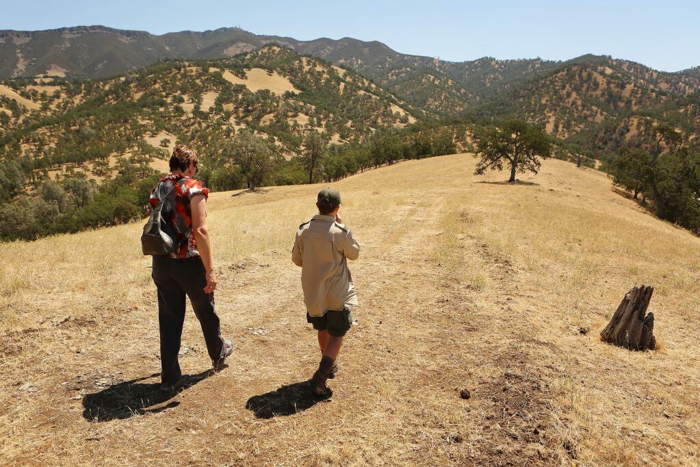 (File photo) Chistina Roberts and her son Darren hike to the top of the ridge line by her family's property at Running Deer Ranch by Lake Berryessa on Friday, July 26, 2013. Robert's mother Judy Ahmann testified to Congress to consider a bill to create a Berryessa Snow Mountain National Conservation Area. (Conner Jay/The Press Democrat)