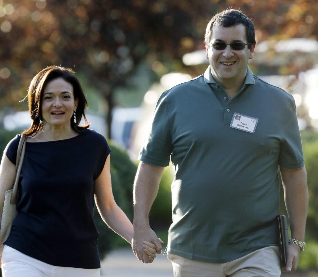 FILE - In this July 10, 2013 file photo, Sheryl Sandberg, COO of Facebook, left, and her husband David Goldberg, CEO of SurveyMonkey, walk to the morning session at the Allen & Company Sun Valley Conference in Sun Valley, Idaho. Goldberg was exercising at a gym in a Mexican resort when he collapsed before he died Friday, May 1, 2015, a person close to the family says. (AP Photo/Rick Bowmer, File)