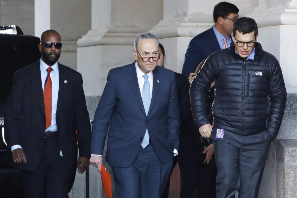 Senate Minority Leader Chuck Schumer, D-N.Y., center, walks to speak to the media outside the Capitol after meeting with President Donald Trump, Friday, Jan. 19, 2018, in Washington. (AP Photo/Jacquelyn Martin)