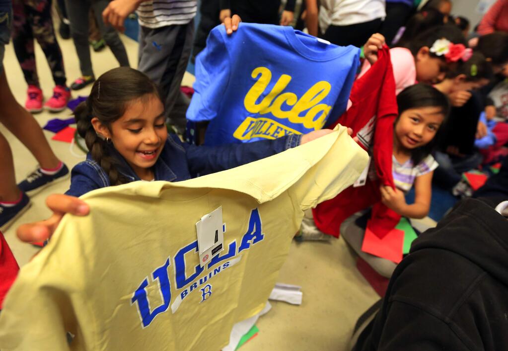 Stephania Nunez,, left, and Hailey Phalavong show off their new college t-shirts at Helen Lehman Elementary School on Friday. About 125 second- and third-grade students received a college t-shirt and a letter from a college grad through The College Tee Project. (JOHN BURGESS / The Press Democrat)