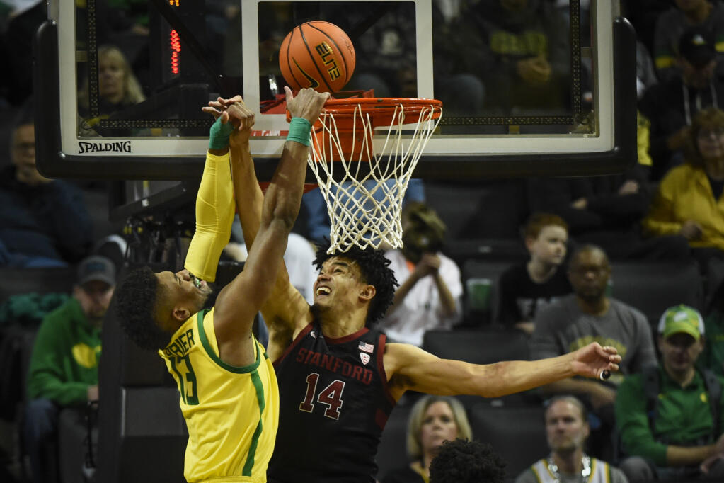 Stanford forward Spencer Jones (14) challenges a shot by Oregon forward Quincy Guerrier (13) during the second half Saturday, March 4, 2023, in Eugene, Oregon. (Andy Nelson / ASSOCIATED PRESS)