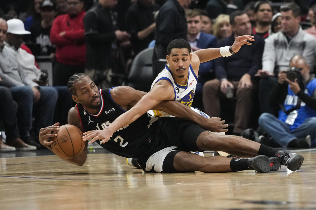 Los Angeles Clippers' Kawhi Leonard (2) and Golden State Warriors' Jordan Poole scramble for the ball during the first half of an NBA basketball game Wednesday, March 15, 2023, in Los Angeles. (AP Photo/Jae C. Hong)