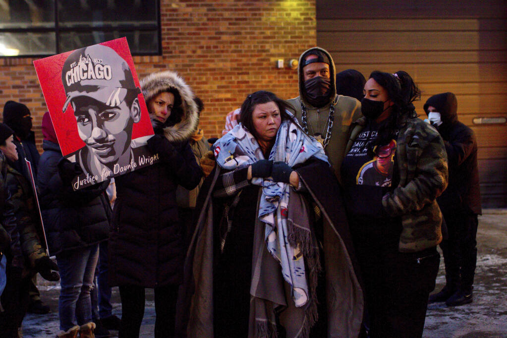 FILE - Katie Bryant, Daunte Wright's mother, is surrounded by community members and activists at the apartment building where activists say Hennepin County Judge Regina Chu lives after former officer Kim Potter was sentenced to two years in prison Friday, Feb. 18, 2022, in Minneapolis.   The suburban Minneapolis city has agreed to pay $3.2 million to the family of Daunte Wright, a Black man who was fatally shot by a police officer who said she confused her gun for her Taser. The tentative settlement also includes changes in police policies and training involving traffic stops like the one that resulted in Wright's death, according to a statement Tuesday, June 21, 2022 from attorneys representing Wright's family.  (AP Photo/Nicole Neri, File)