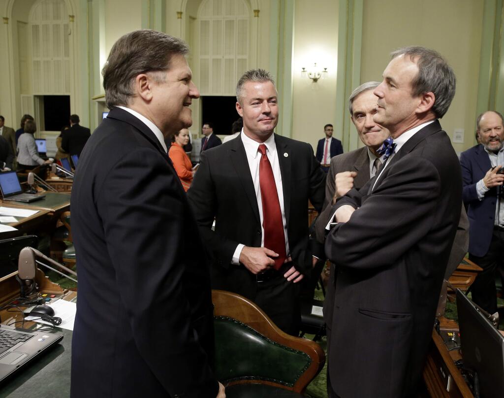 State Sen. Bob Hertzberg, D-Van Nuys, left, talks with Charles Munger, Jr., right a Stanford physicist, who is a frequent contributor to Republican causes, as Assemblyman Travis Allen, R-Huntington Beach, second from left, and former Republican lawmaker Phil Wyman listen at the Capitol in Sacramento, Calif., Monday, Dec. 1, 2014. The Legislature met for an organizational session where recently elected lawmakers took the oath of office. (AP Photo/Rich Pedroncelli)