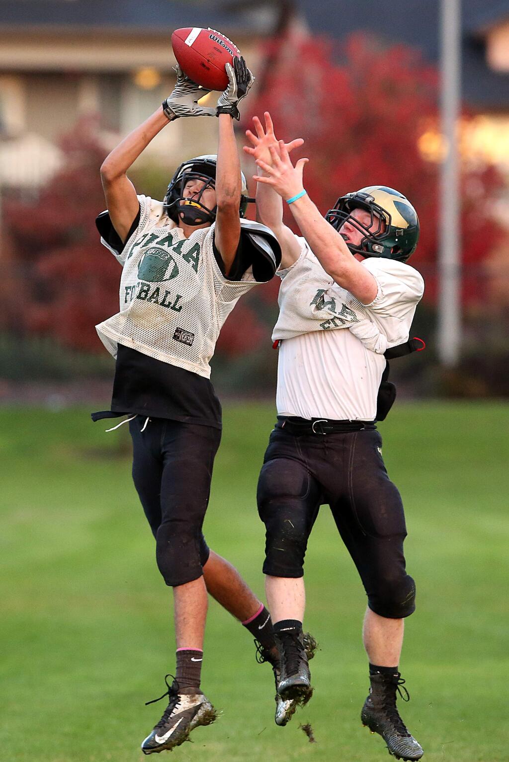 Maria Carrillo's Bailey Brown, left, goes up for the ball with Josh Groesbeck during the football practice held at Maria Carrillo High School, Thursday, November 20, 2014. (Crista Jeremiason / The Press Democrat)