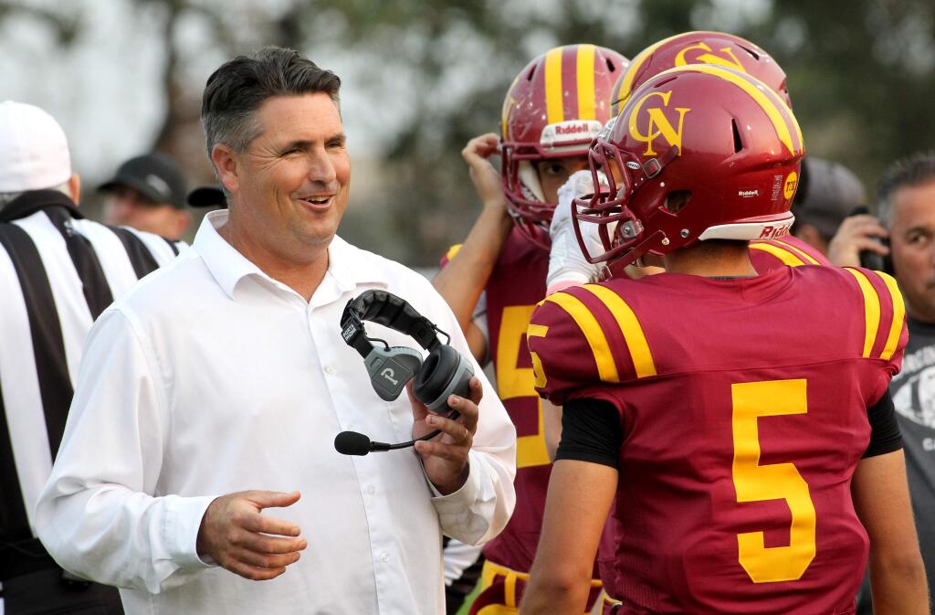 Cardinal Newman's head coach Paul Cronin smiles as player Julio Angel watches before the game against Sutter at Cardinal Newman High School in Santa Rosa, on Friday, Aug. 24, 2018. (Photo by Darryl Bush / For The Press Democrat)