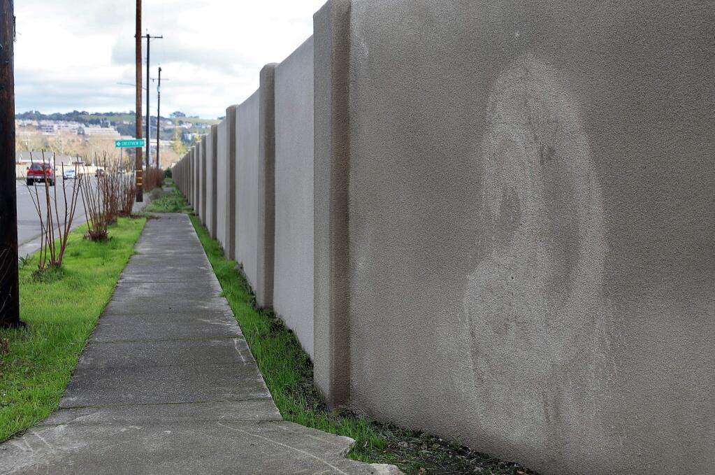 The remnants of graffiti are still visible on the wall along Hopper Avenue, at Coffey Lane, in Santa Rosa on Monday, January 13, 2020. (Christopher Chung/ The Press Democrat)