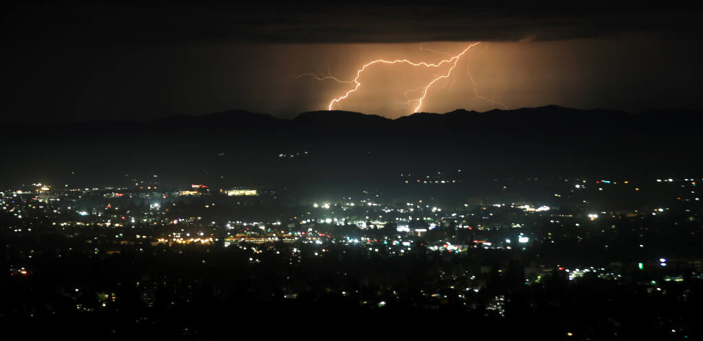 Lightning bolts, Sunday, Aug. 16, 2020, strike out over the coast before moving inland over Santa Rosa. (Kent Porter / The Press Democrat) 2020