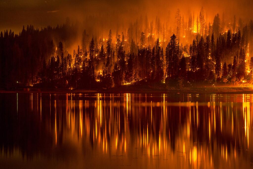 This Sunday, Sept. 14, 2014 photo shows fire as it approaches the shore of Bass Lake, Calif. (AP Photo/YosemiteLandscapes.com, Darvin Atkeson )