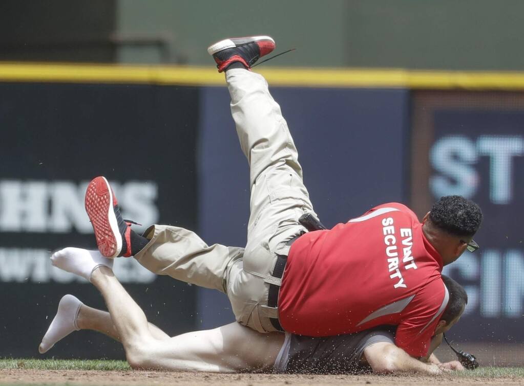 A security guard tackles a fan that ran on the field during the second inning of a baseball game between the Milwaukee Brewers and the San Francisco Giants Thursday, June 8, 2017, in Milwaukee. (AP Photo/Morry Gash)