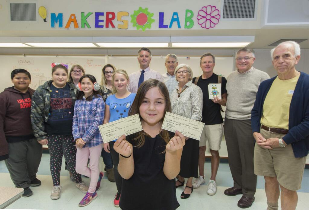 Student Eva Rose Logizerio, 10, holds two checks that total $26,000, which will be used to create a Maker Lab at Sassarini Elementary School. The funds were donated by the Kiwanis of Sonoma Plaza. (Photo by Robbi Pengelly/Index-Tribune)
