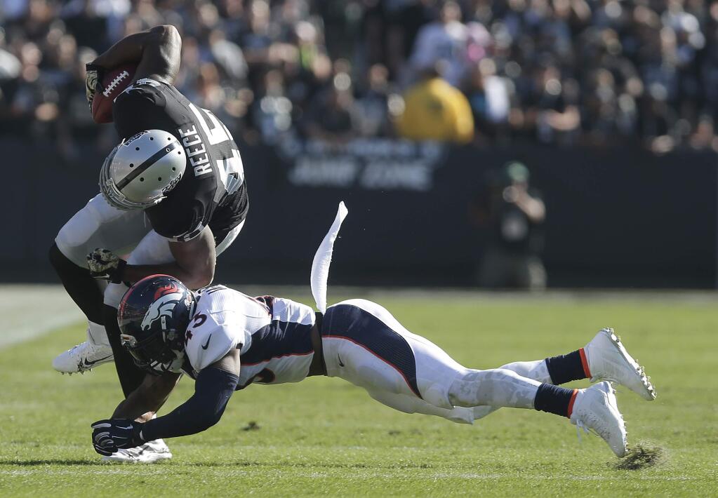 Oakland Raiders fullback Marcel Reece (45) is tackled by Denver Broncos strong safety T.J. Ward (43) during the first quarter of an NFL football game in Oakland, Calif., Sunday, Nov. 9, 2014. (AP Photo/Marcio Jose Sanchez)