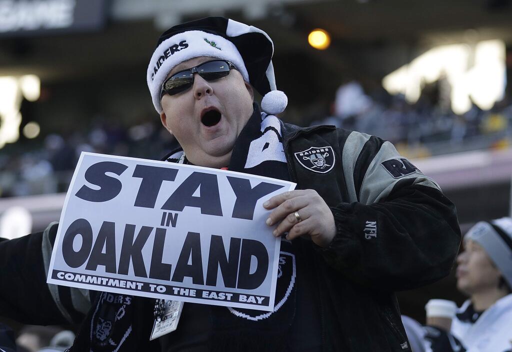 A fan hold up a sign about the Oakland Raiders' possible move before a game between the Oakland Raiders and the Indianapolis Colts in Oakland, Saturday, Dec. 24, 2016. (AP Photo/Marcio Jose Sanchez)