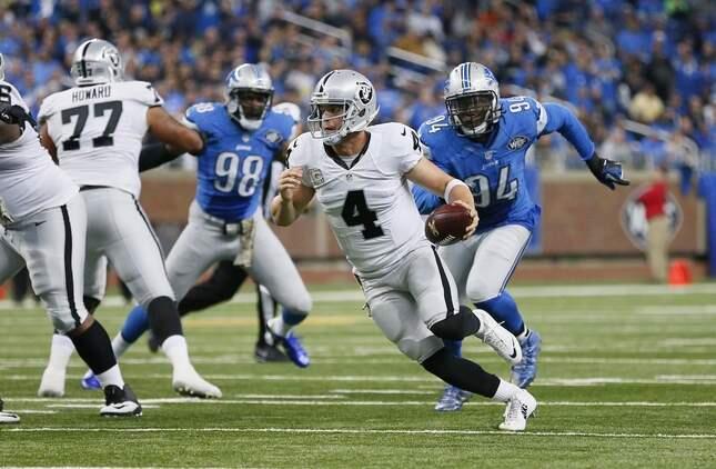 Oakland Raiders quarterback Derek Carr (4) scrambles for yardage while chased by Detroit Lions defensive end Ezekiel Ansah (94) during the second half of an NFL football game, Sunday, Nov. 22, 2015, in Detroit. (AP Photo/Rick Osentoski)