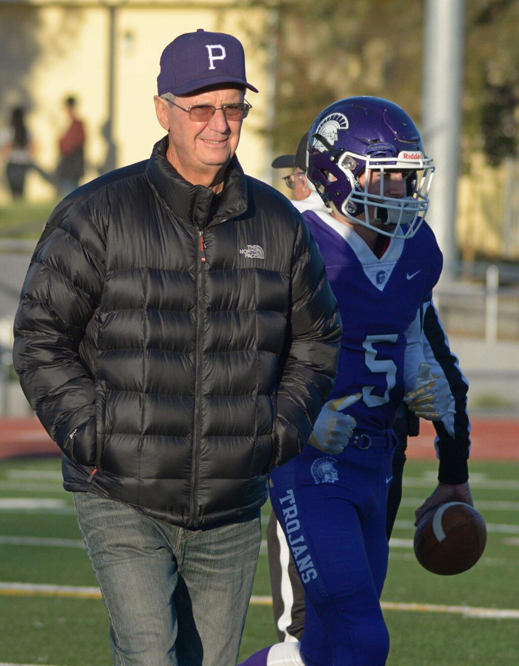 SUMNER FOWLER/FOR THE ARGUS-COURIERFormer Petaluma High football coach Steve Ellison is escorted onto the field by Trojan running back Garrett Fraites for the coin flip prior to the first football game played on the newly refurbished Steve Ellison Field.