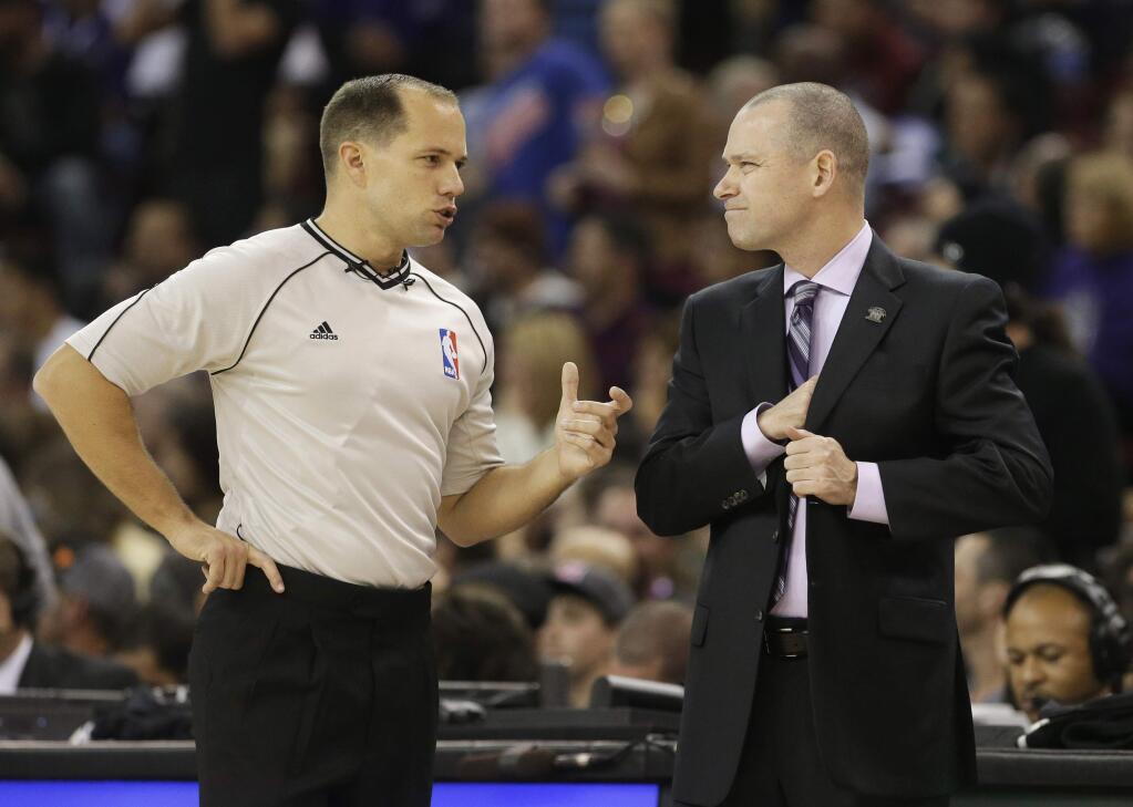 Official John Goble talks with Sacramento Kings head coach Michael Malone, right, about a foul call during a break in the third quarter of an NBA basketball game against the Utah Jazz in Sacramento, Calif., Monday, Dec. 8, 2014. The Kings won 101-92. (AP Photo/Rich Pedroncelli)