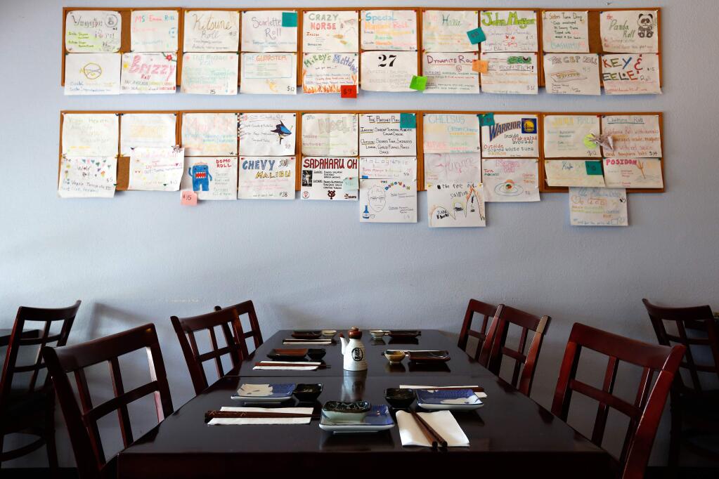 Empty tables beneath a hand-drawn menu board at Kaede Japanese Restaurant in the Larkfield Shopping Center, where some businesses have struggled since the Tubbs fire. (ALVIN JORANADA / The Press Democrat)