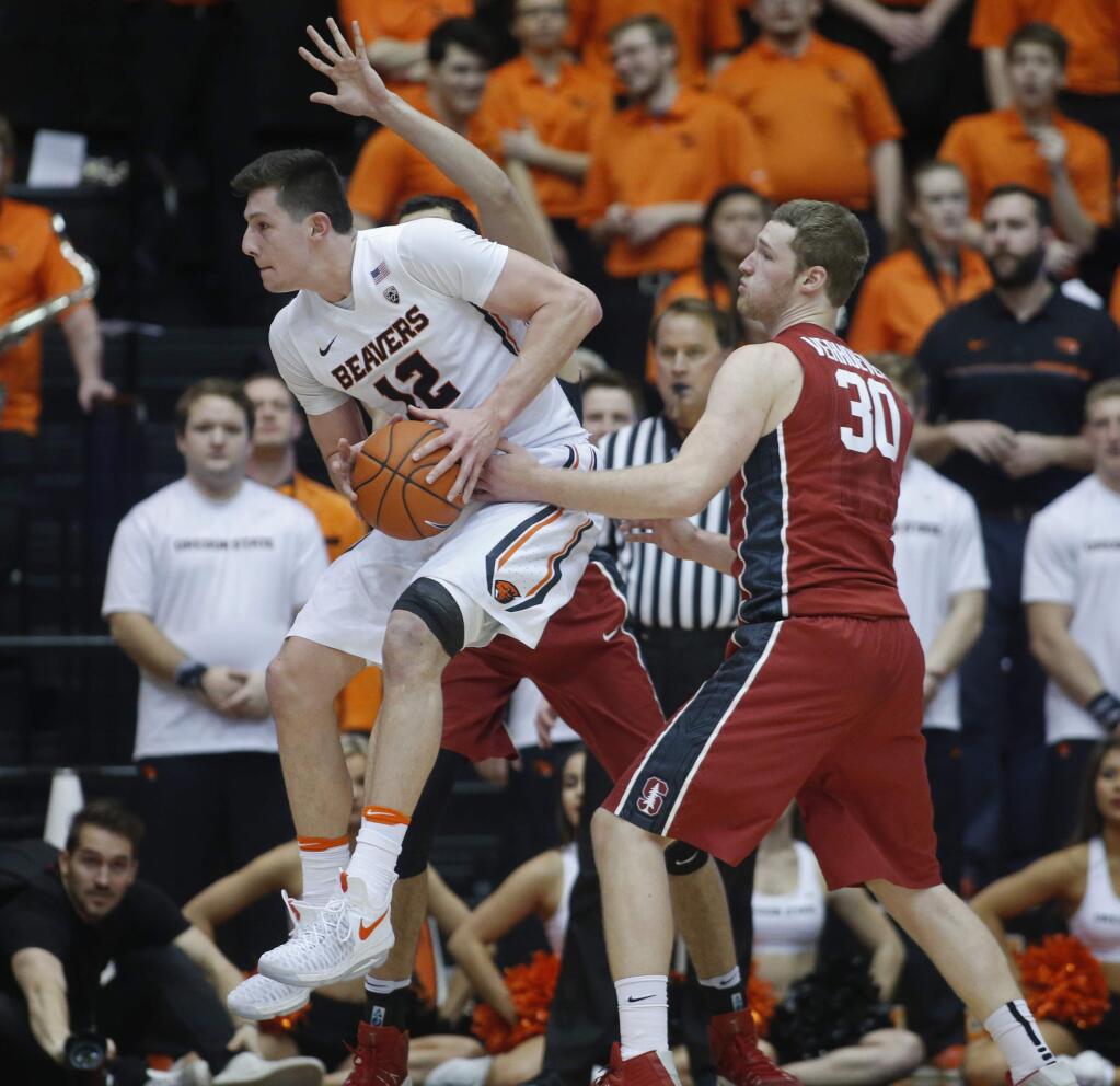 Oregon State's Drew Eubanks (12) jumps past Stanford's Grant Verhoeven (30) during first half of an NCAA college basketball game in Corvallis, Ore., Thursday, Jan. 19, 2017. (AP Photo/Timothy J. Gonzalez)