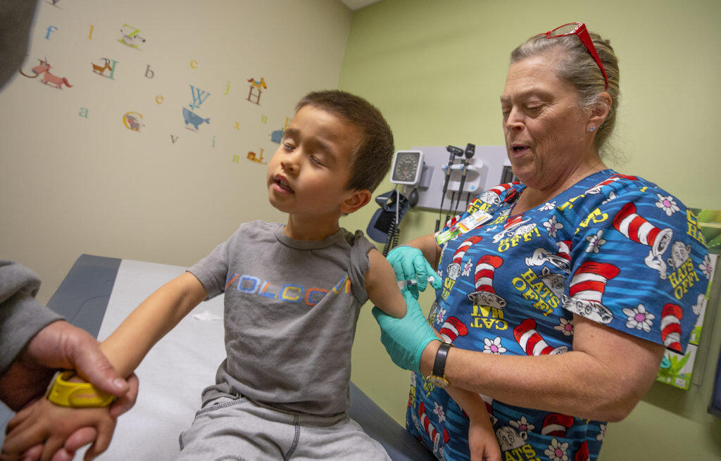 Sutter pediatric medical assistant Stephanie Cheney give a measles, mumps and rubella vaccination shot to Makaiah Cochran, 4, of Healdsburg at their Santa Rosa office.  (photo by John Burgess/The Press Democrat)