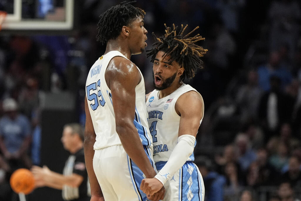 North Carolina guard RJ Davis, right, and North Carolina forward Harrison Ingram celebrate a three-point shot against Michigan State during the first half of a second-round game in the NCAA Tournament, Saturday, March 23, 2024, in Charlotte, North Carolina. (Mike Stewart / ASSOCIATED PRESS)