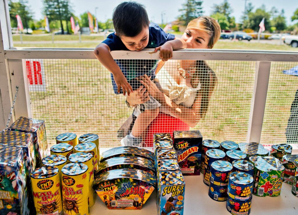 JoJo Lugo-Valencia, 2, shops for fireworks with his mother Mia Valencia at the Calvary Life Church fireworks booth on Rohnert Park Expressway in Rohnert Park, Calif., on June 30, 2013. (Alvin Jornada / For The Press Democrat)