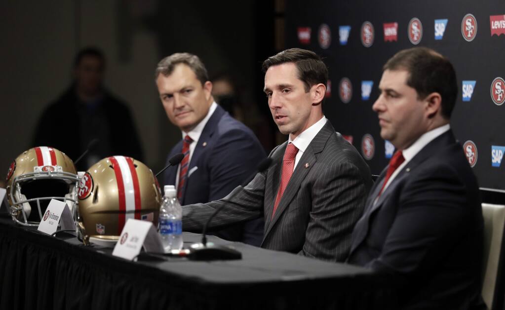 San Francisco 49ers head coach Kyle Shanahan, center, answers questions next to general manager John Lynch, left, and owner Jed York during a press conference Thursday, Feb. 9, 2017, in Santa Clara. (AP Photo/Marcio Jose Sanchez)