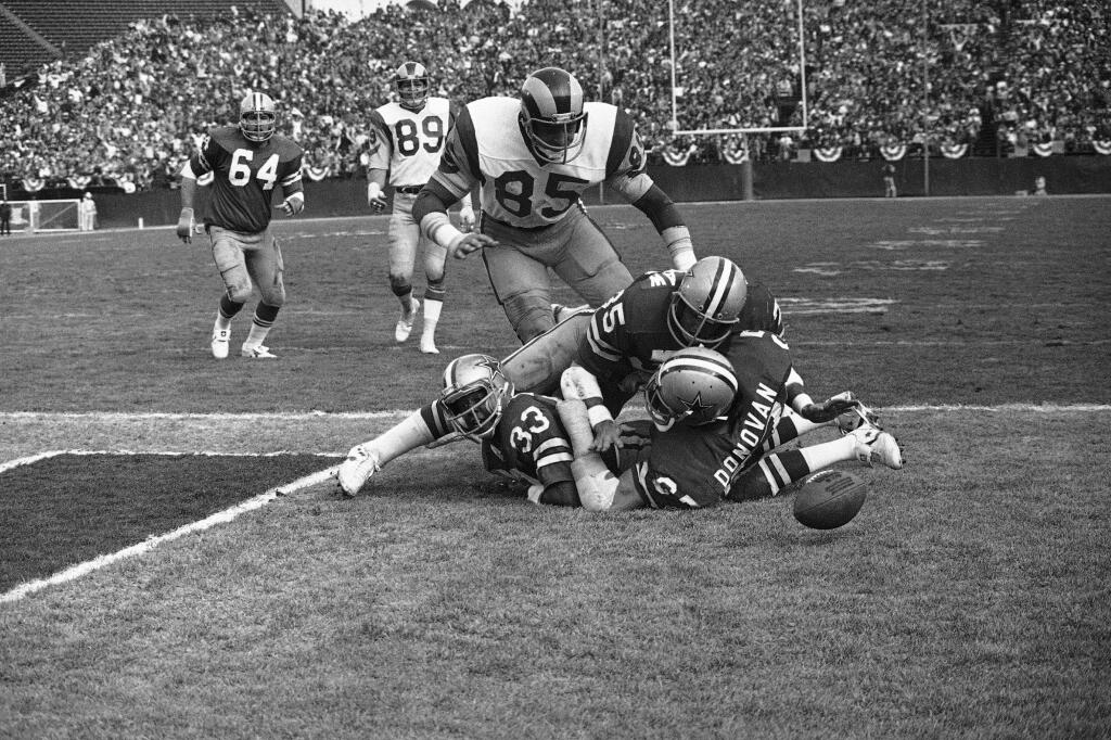 Jack Youngblood (85) of the Los Angeles Rams comes over the fumbling Dallas Cowboys on his way to recover an end-zone fumble by Scott Laidlaw (35) of the Dallas Cowboys in the NFC championship game in Los Angeles on Sunday, Jan. 7, 1979. (AP Photo)
