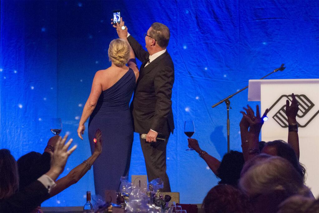 Boys & Girls Clubs of Sonoma executive director Cary Dacy and board president Dub Hay surprise the dining crowd by taking a selfie with them at the Sweethearts Gala fundraiser. (Photo by Robbi Pengelly/Index-Tribune)