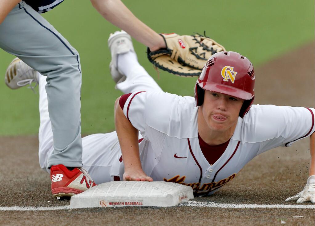 Cardinal Newman's Nathan Phelps dives safely back to first base during a game between Rancho Cotate and Cardinal Newman high schools in Santa Rosa on Friday, March 13, 2020. (Alvin Jornada / The Press Democrat)