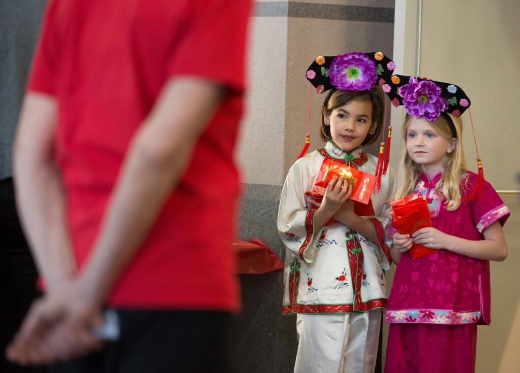 Keelyn Walker, left, and Brook Szczekocki, greet guests arriving for a Chinese New Year celebration at the Veteran's Memorial Building in Santa Rosa on Saturday, Feb. 21, 2015. The Redwood Empire Chinese Association hosted the event honoring the year of the Ram. (Jeremy Portje / For The Press Democrat)