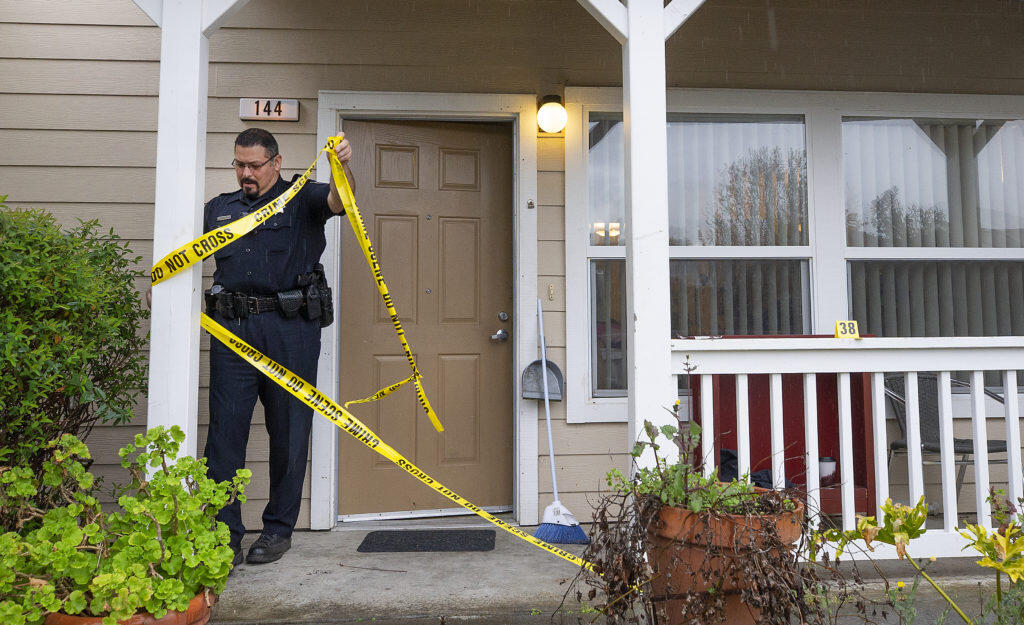 Sgt. Nick Castaneda removes crime scene tape from a Canyon Run Apartments unit where an 18 year-old male stabbed and killed his 25 year-old brother on Wednesday night, March 28, 2019. (photo by John Burgess/The Press Democrat)