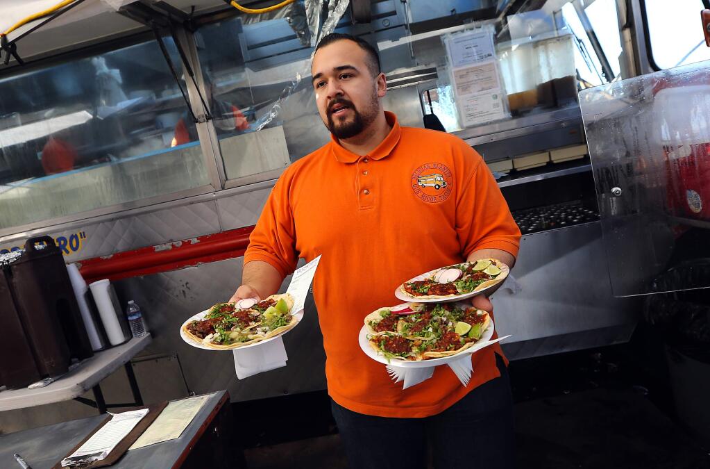 Fernando Reyes serves up plates of tacos at La Fondita restaurant, which is across the street from the Camp Michela, a tent city of homeless advocates. (JOHN BURGESS / The Press Democrat)