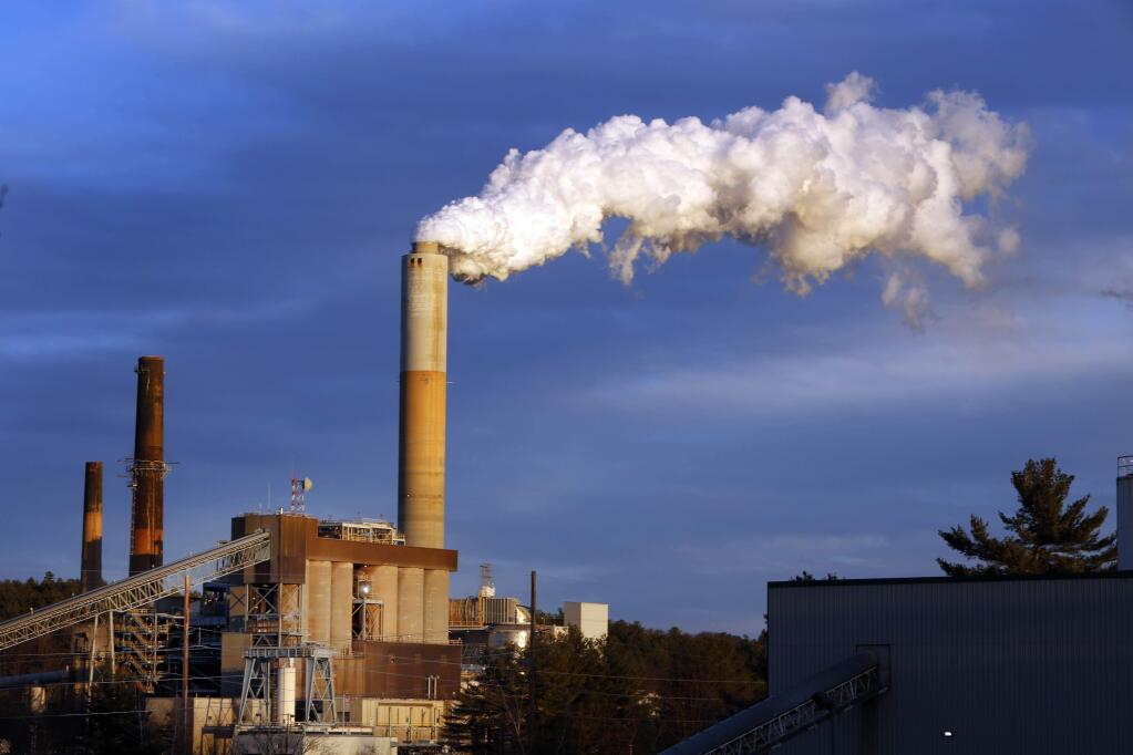 FILE - In this Jan. 20, 2015 file photo, a plume of steam billows from the coal-fired Merrimack Station in Bow, N.H. Earth is likely to hit more dangerous levels of warming even sooner if the U.S. pulls back from its pledge to cut carbon dioxide pollution because America contributes so much to rising temperatures, scientists said. (AP Photo/Jim Cole, File)