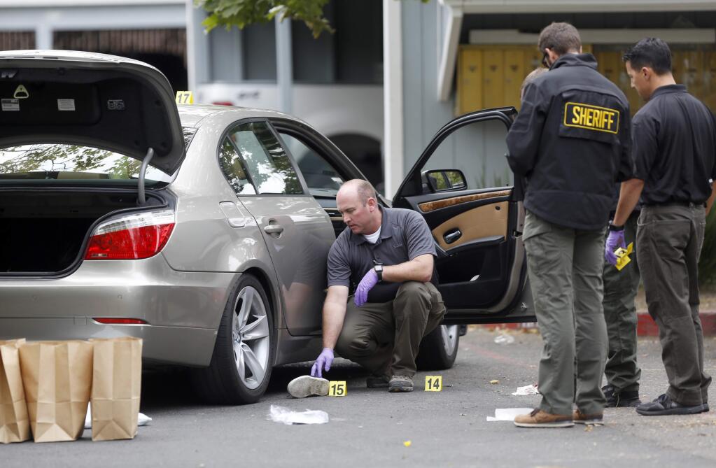 Sonoma County sheriff's deputies and detectives collect evidence from a gang related shooting near a Corby Avenue apartment complex in Santa Rosa, July 6, 2015. (BETH SCHLANKER/ The Press Democrat)