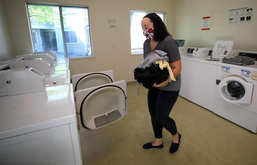 Tiffany Lacey, 32, uses the laundry room at her apartment complex in Santa Rosa on Friday, April 24, 2020 after getting off from her job in nutrition services at an area hospital. (Kent Porter / The Press Democrat) 2020