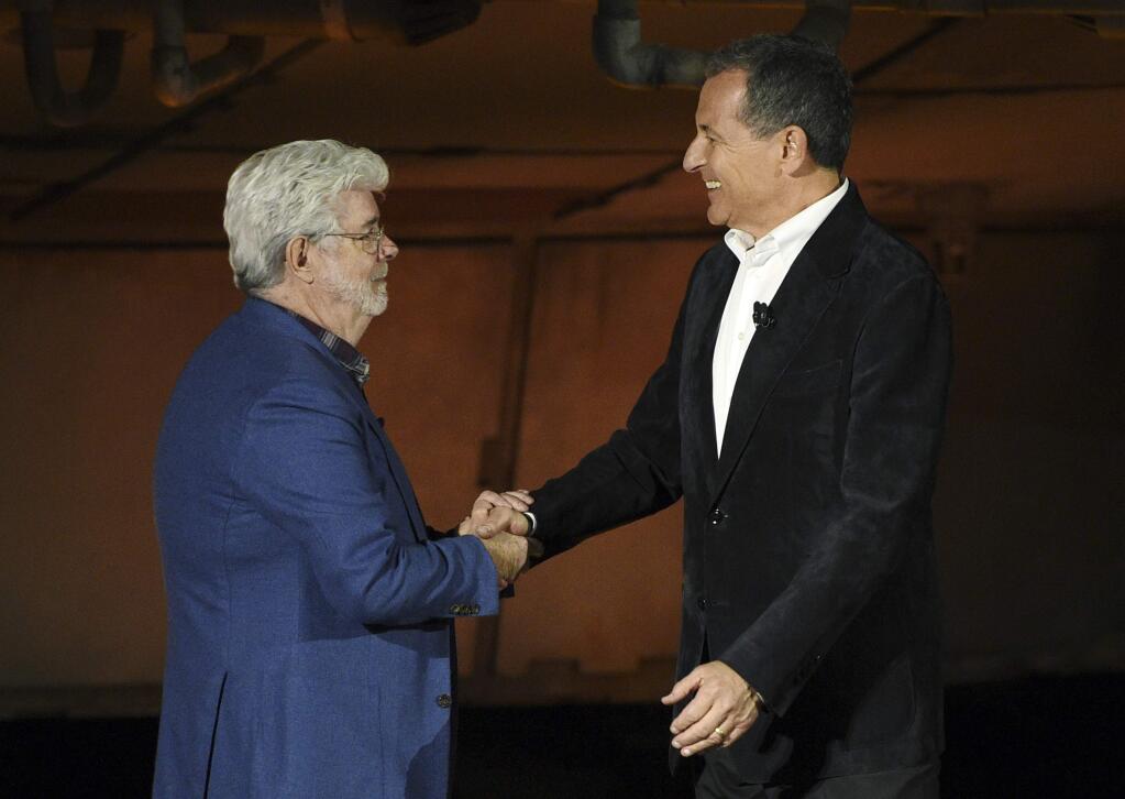 'Star Wars' film franchise creator George Lucas, left, shakes hands with Walt Disney Co. Chairman and CEO Bob Iger during a dedication ceremony for the new Star Wars: Galaxy's Edge attraction at Disneyland Park, Wednesday, May 29, 2019, in Anaheim, Calif. (Photo by Chris Pizzello/Invision/AP)