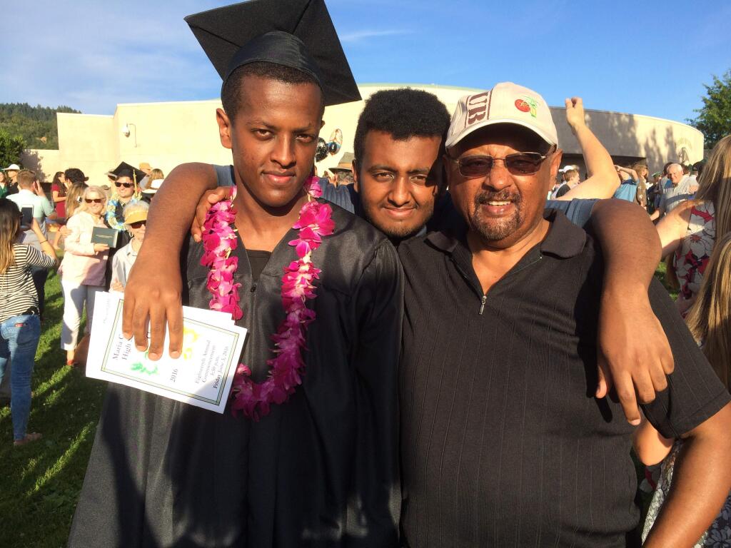 Endrias Atlaw, left, poses for a photo with his brother, Nat Atlaw, center, and father, Fesseha Atlaw, after graduating from Maria Carrillo High School in June. Endrias Atlaw died in a car crash early Sunday, Oct. 9, 2016. (Family photo)
