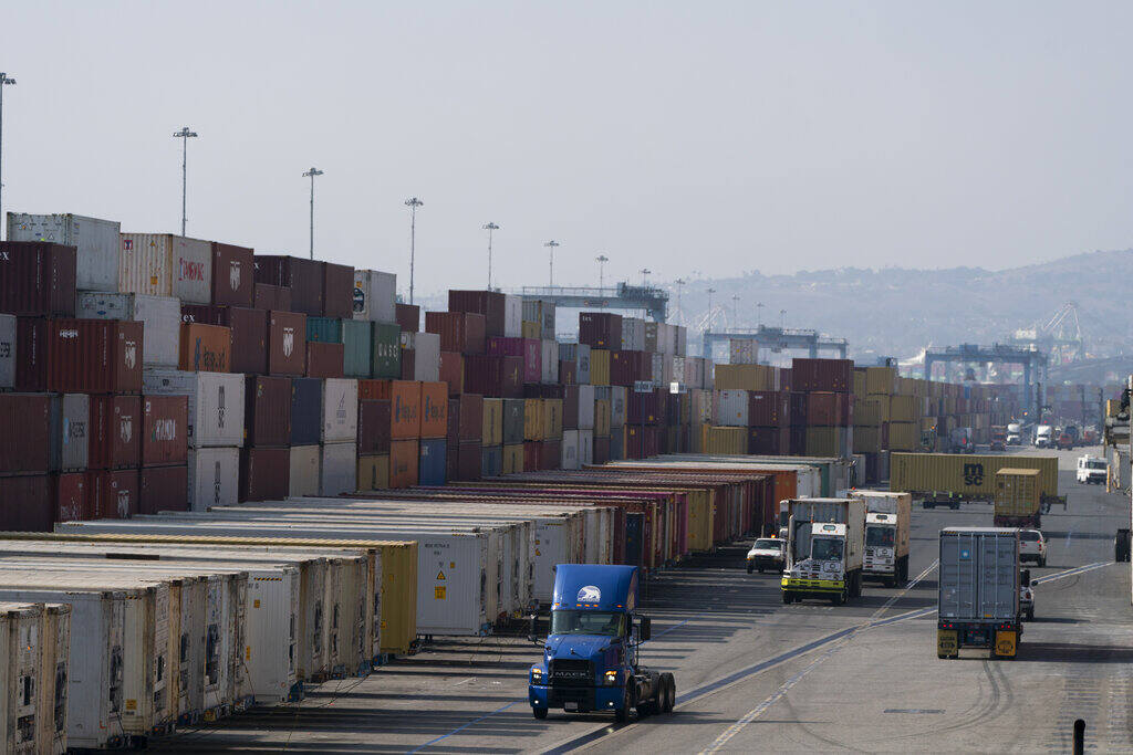 Trucks load and unload shipping containers at the Port of Long Beach. (JAE C. HONG / Associated Press)