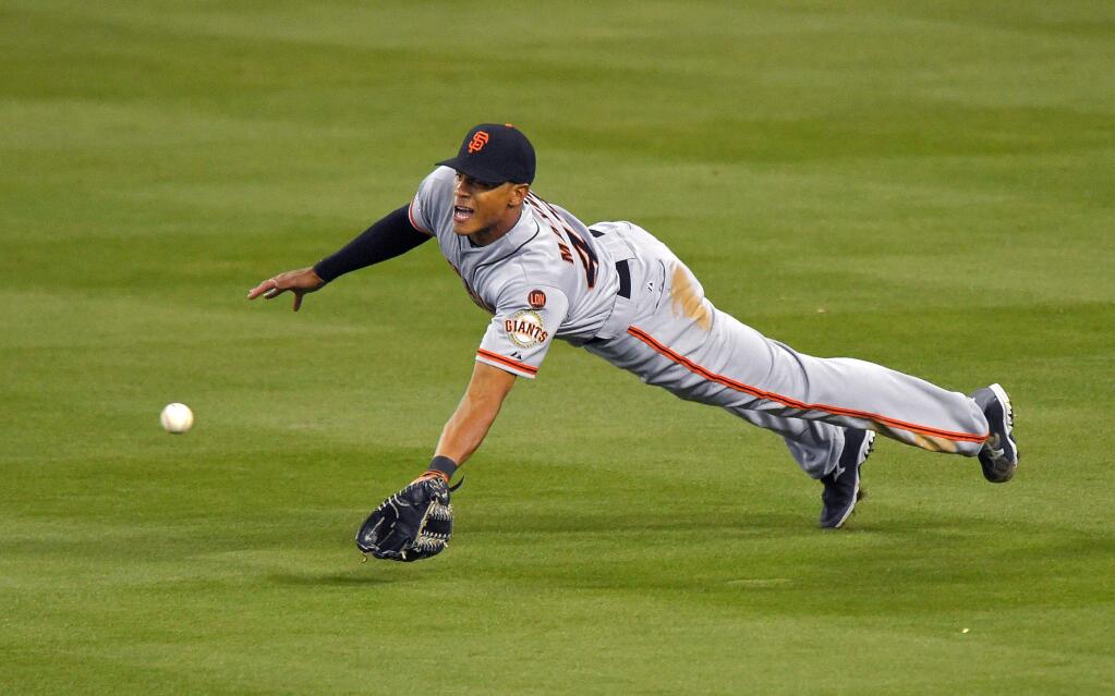 San Francisco Giants right fielder Justin Maxwell makes a diving catch on a ball hit by Los Angeles Dodgers' Jimmy Rollins during the second inning of a baseball game, Monday, April 27, 2015, in Los Angeles. (AP Photo/Mark J. Terrill)