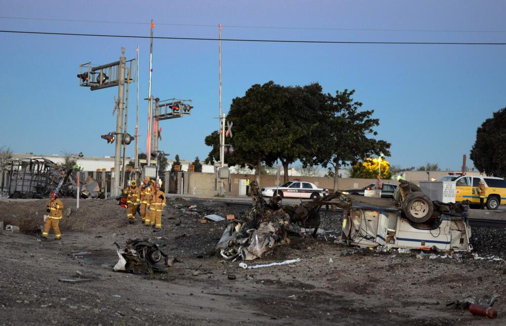 Firefighters arrive to attend to injured passengers at the scene of a Metrolink accident, Tuesday, Feb. 24, 2015, in Oxnard, Calif. Three cars of a Southern California Metrolink commuter train have derailed and tumbled onto their sides after a collision with a truck on tracks in Ventura County, northwest of Los Angeles. (AP Photo/Johnny Corona)