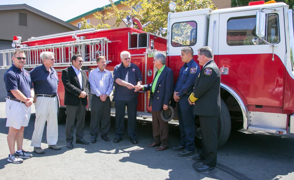 Julie Vader/Special to the Index-TribuneFrom left, Terry Leen, Bill Norton, Rigo Castillo, Sonoma Mayor David Cook, Ray Brunton, Patrick Garcia, Ismael Gonzalez, and Sonoma Valley Fire Chief Mark Freeman pose for a ceremonial key exchange for a firetruck headed to Ecuanduereo, Michoacan, Mexico.