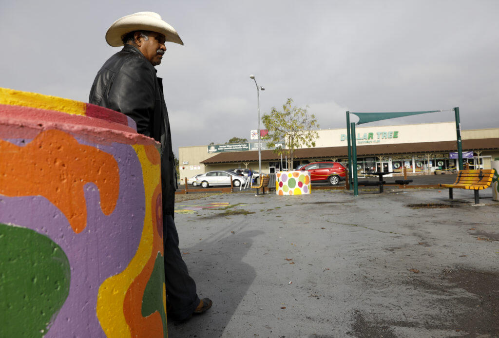Manuel Espitia stand next to a concrete planter painted by Artstart in the plaza in front of the Dollar Tree in the Roseland area of Santa Rosa on Tuesday, December 18, 2018. (BETH SCHLANKER/ The Press Democrat)