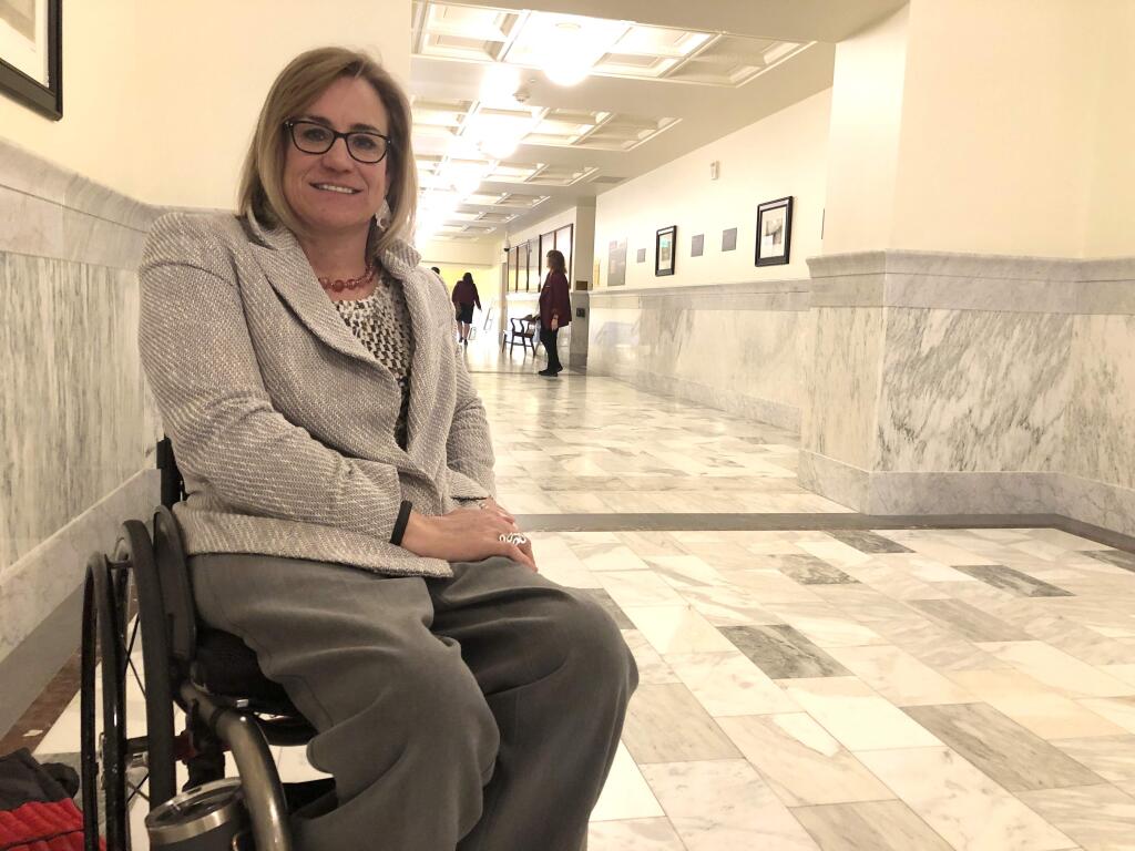 Democratic state Rep. Muffy poses in the hallway of the Idaho Statehouse in Boise, Idaho, Wednesday, Feb. 26, 2020. Idaho moved closer Wednesday to banning transgender women from competing in women's sports despite warnings that such a law is unconstitutional and uncertainties about how the NCAA might react. Davis, a seven-time medalist in Paralympic Games, said it could limit female participation because of the tests. (AP Photo/Keith Riddler)
